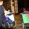 photo of 3 wheelchair users in front of Omni hotel with 2 policemen standing over them.